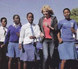 Charlize Theron dancing with a group of African youth