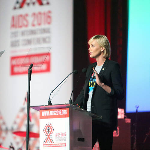 Charlize Theron at a podium giving a speech