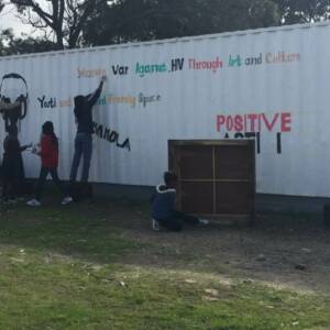 Group of youth painting the side of a white building