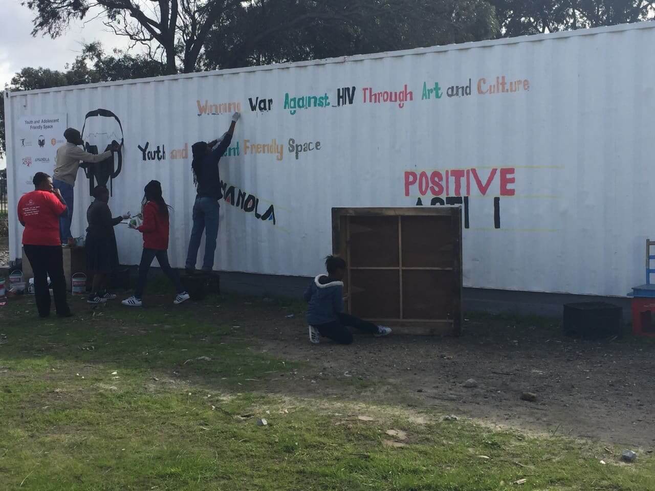 Group of youth painting the side of a white building