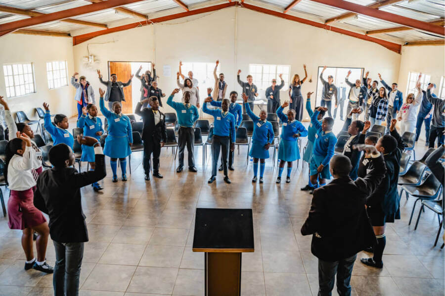 A classroom of young people participating in an exercise