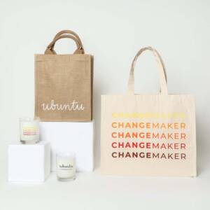 A group of bags and candles branded with the Changemaker logo