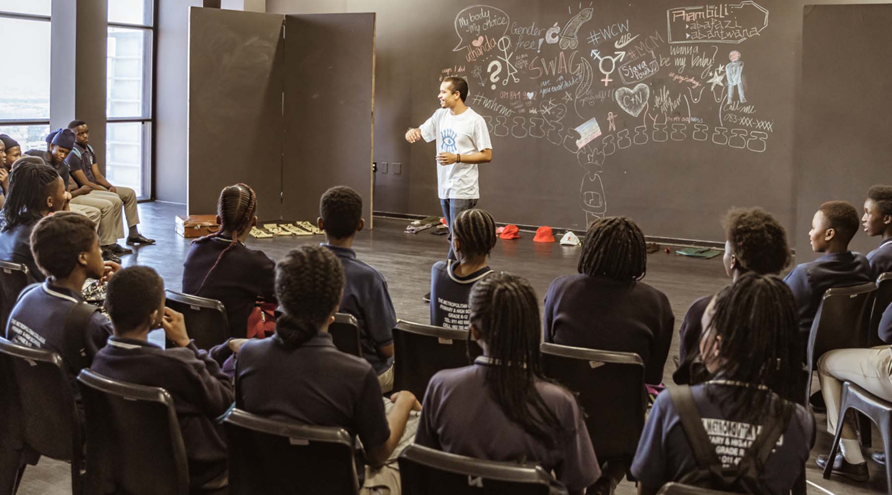 teacher leading a classroom discussion in front of a chalkboard