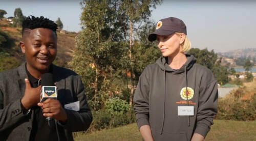 Charlize Theron standing next to man who is interviewing her